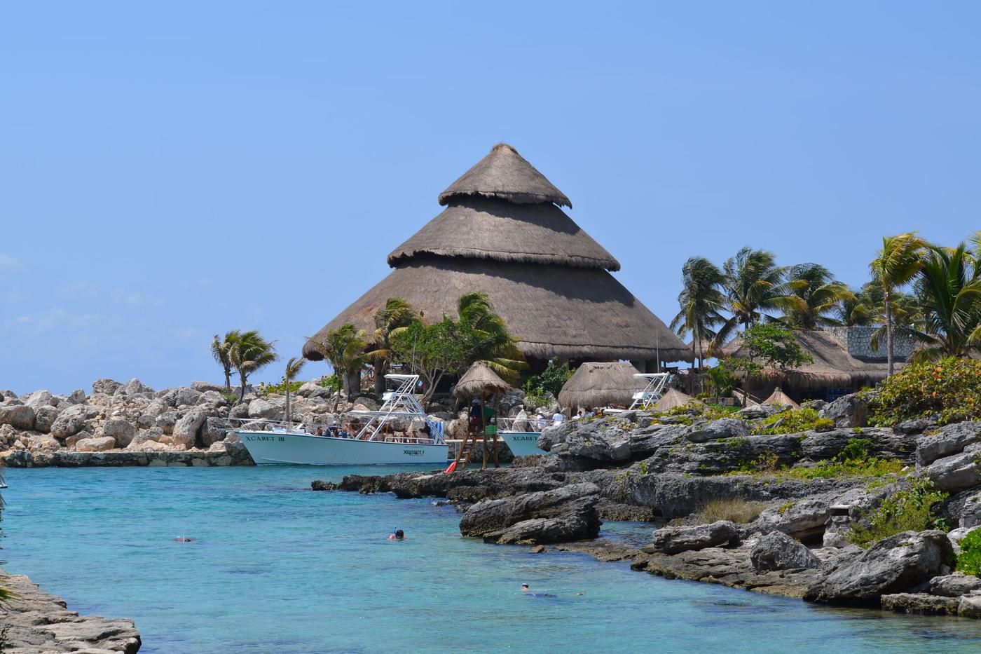The Xcaret park inlet and its tall cone shaped palapa seen from the rocks, Quintana Roo, Mexico